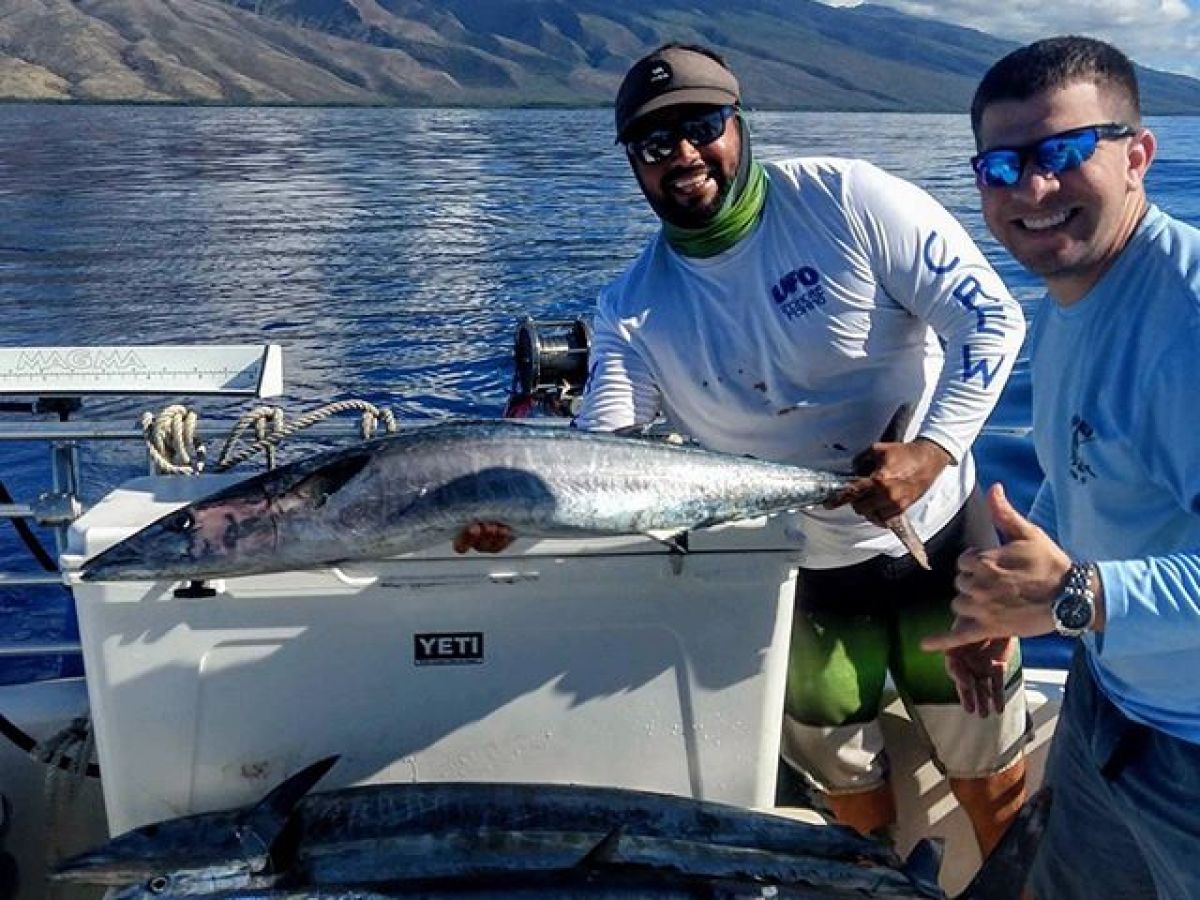 a man holding a fish on a boat