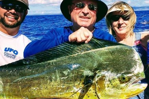 a group of people standing next to a body of water