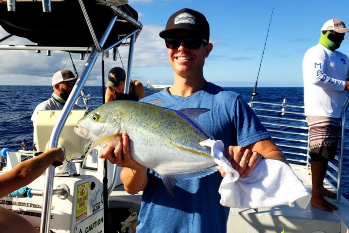 a man holding a fish on a boat